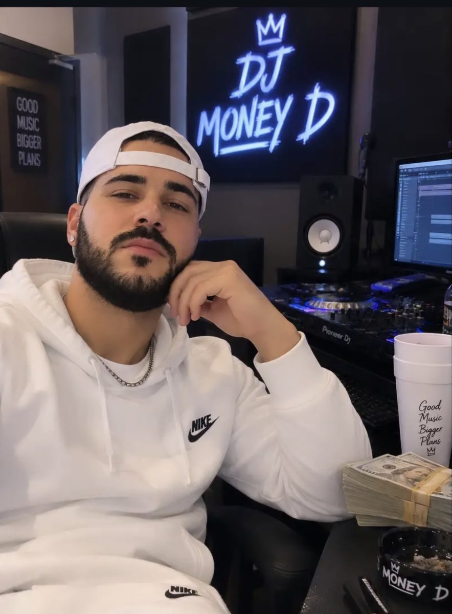 DJ Money D in the studio under his neon sign